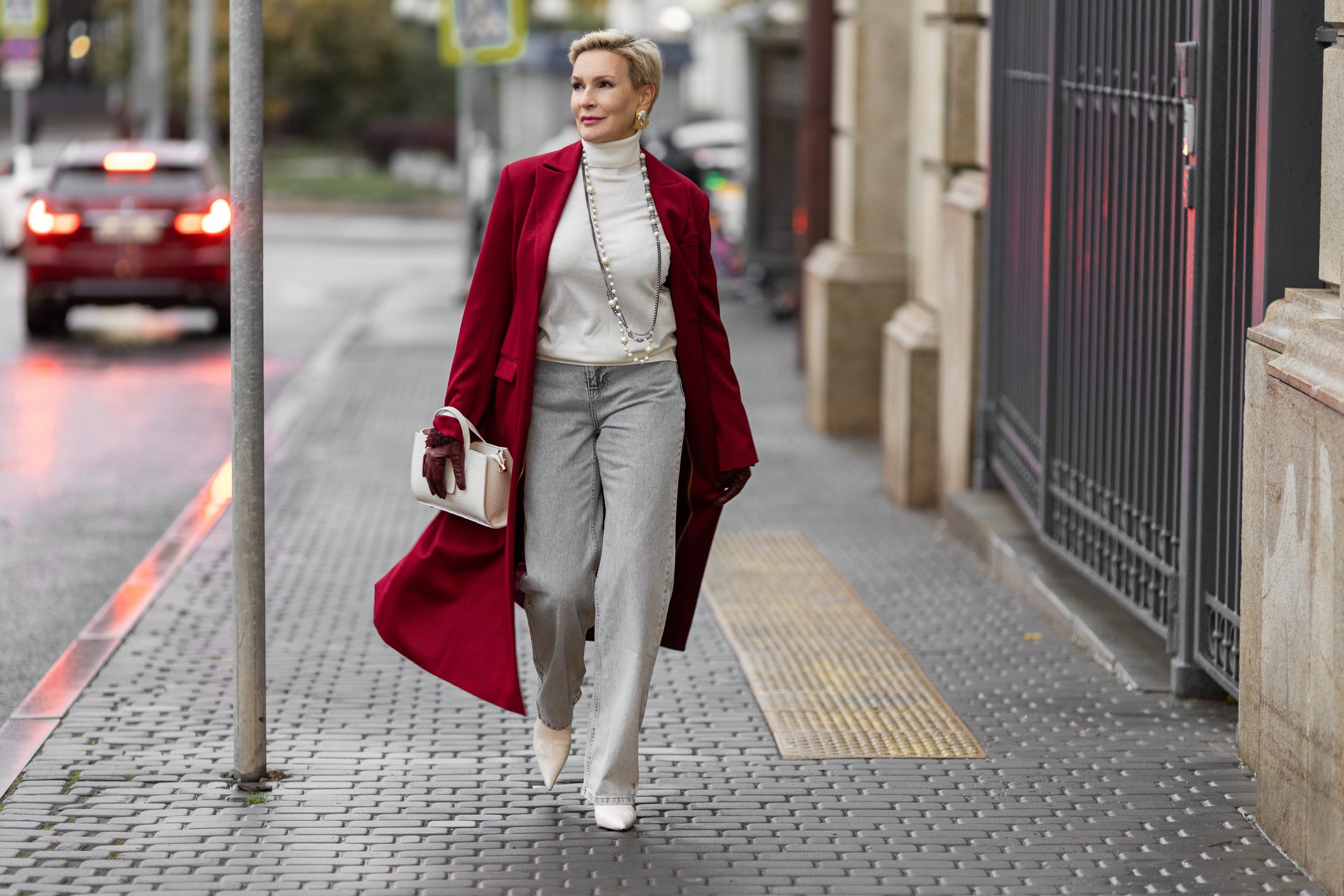 Woman in red coat walking on sidewalk