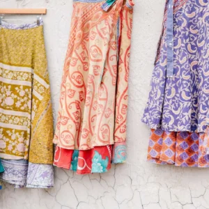 Colorful patterned skirts hanging on wall.